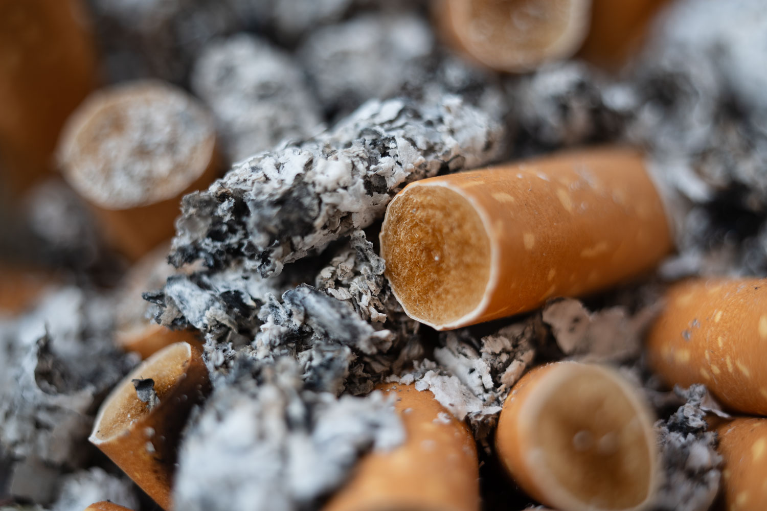 Ein ausgedrückter, kalter Zigarettenstummel liegt in einem Aschenbecher.