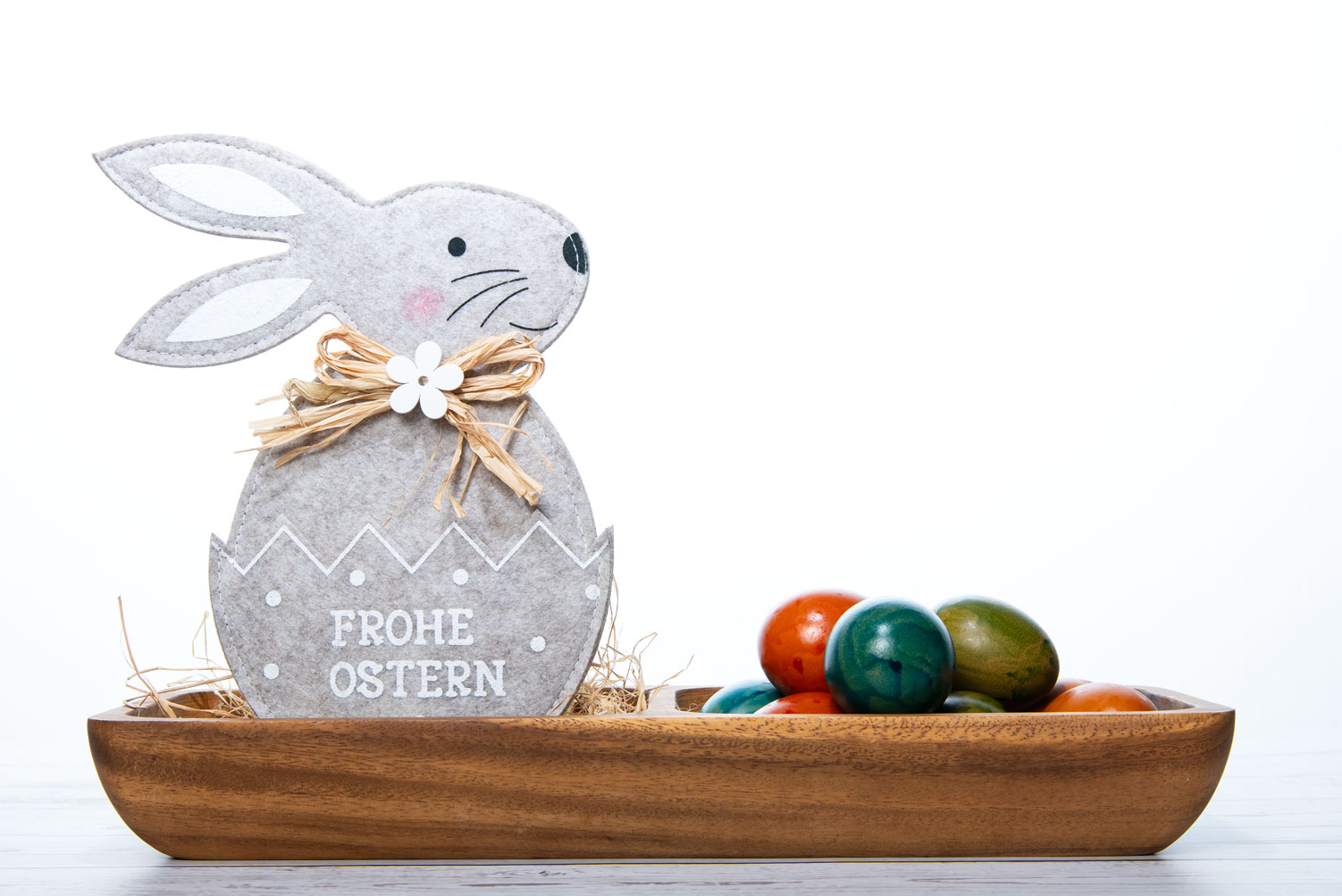 Ein kleiner Hase aus Filz mit dem Schriftzug "Frohe Ostern" als fertige Grußkarte.