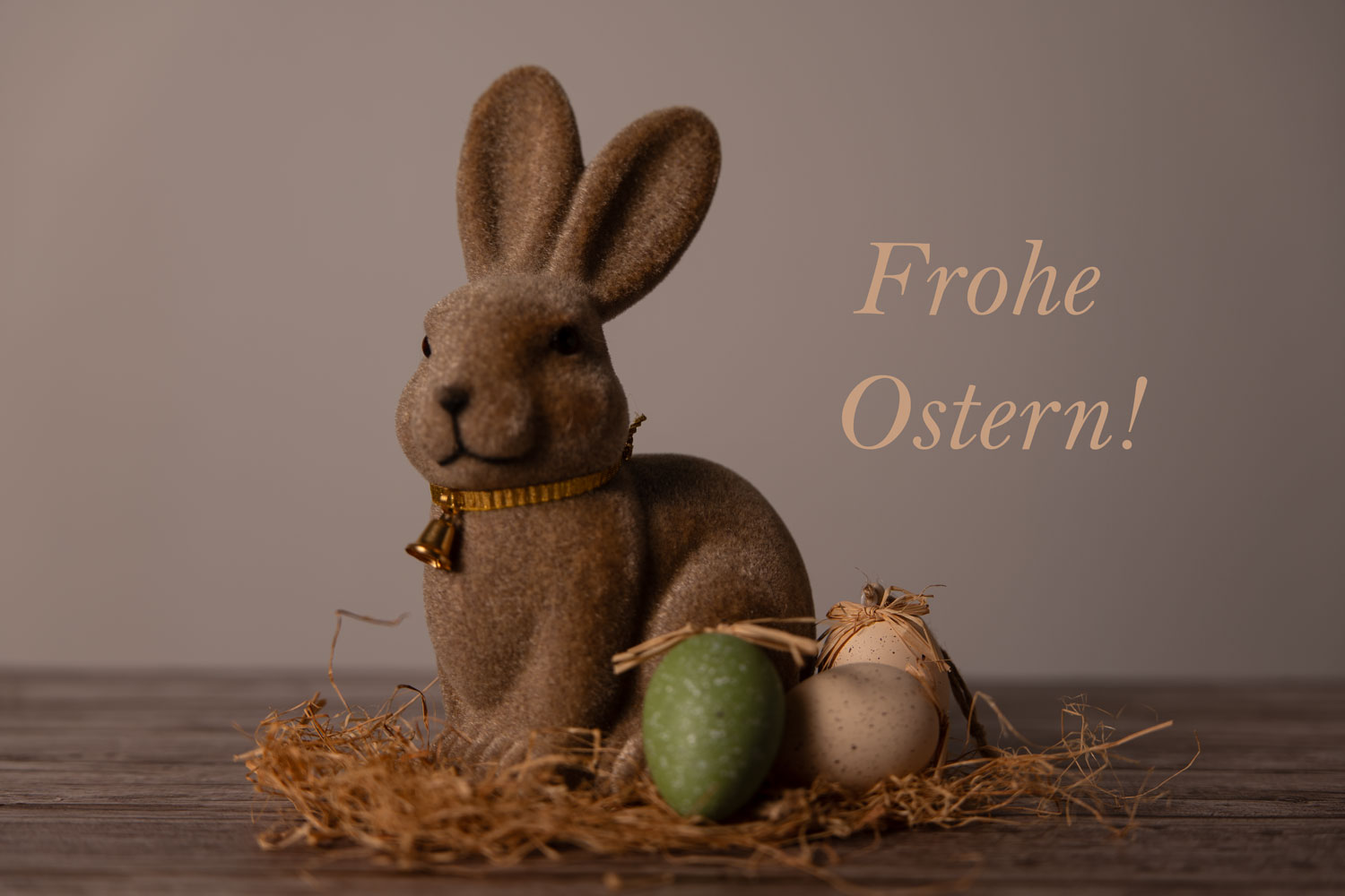 Ein brauner Deko-Osterhase mit kleinen Ostereiern in einem Strohnest und dem Schriftzug „Frohe Ostern!“ als Symbolbild für das Frühlingsfest.