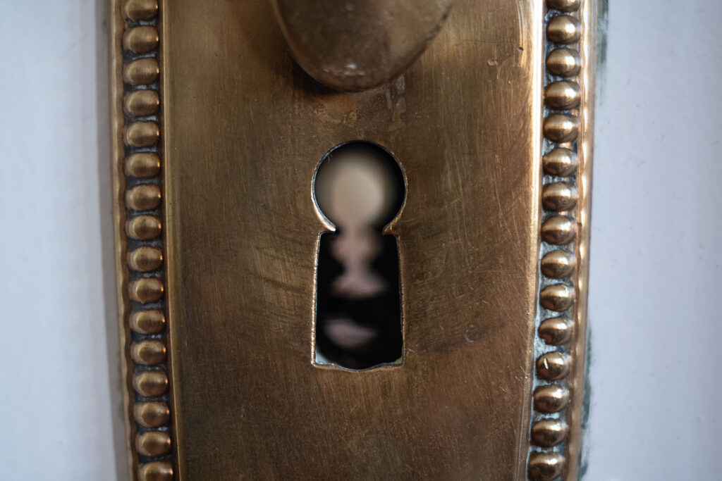 Nahaufnahme eines antiken Messing-Schlüssellochs als Symbolbild für Privatsphäre, Datenschutz, Spionage und Haussicherheit.